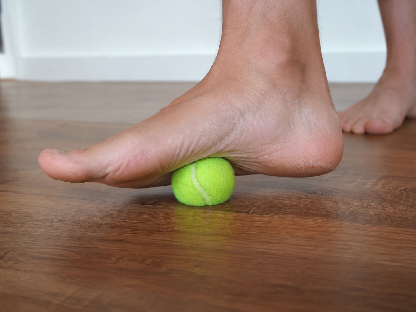 Auto-massage du fascia plantaire avec une balle de tennis — roulé sous la voûte plantaire