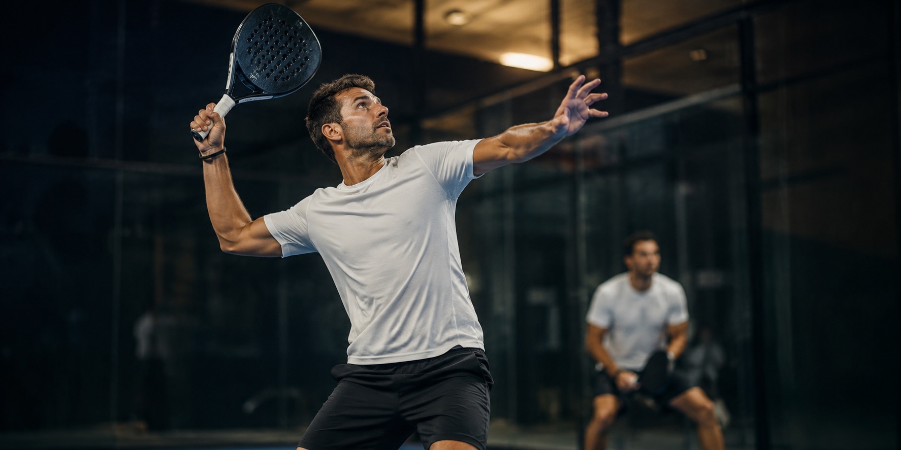 Joueurs de padel en plein match sur court intérieur, sollicitant intensément coude, épaule et dos